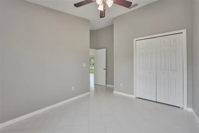 an empty room with a ceiling fan and a window