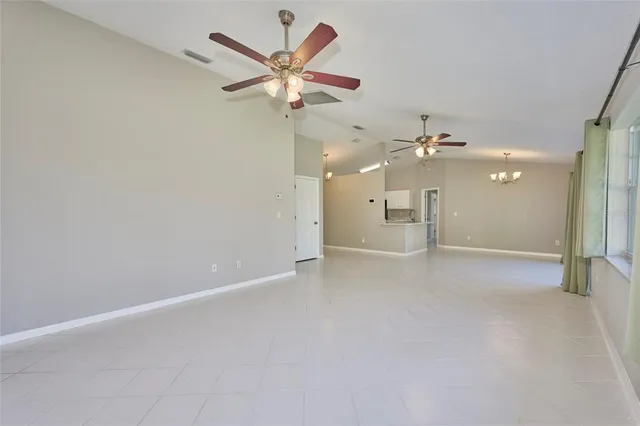 wooden floor in an empty room and a chandelier fan