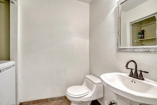 a bathroom with a toilet a sink and mirror