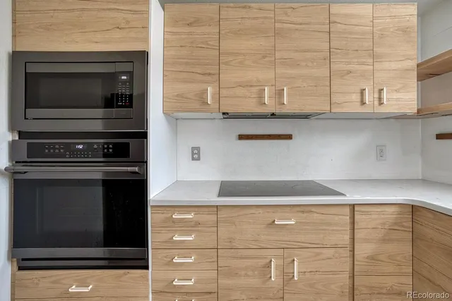 a kitchen with granite countertop white cabinets and black appliances