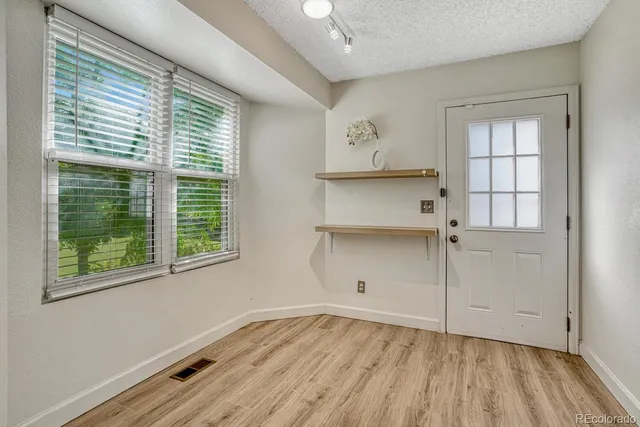 an empty room with wooden floor and windows