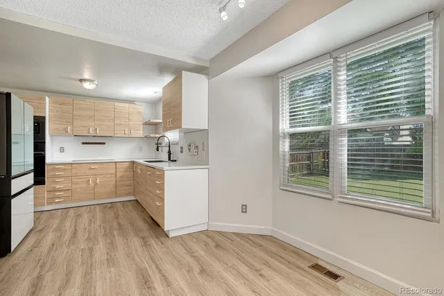 a kitchen with wooden floors and white cabinets