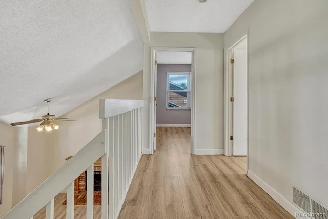 a view of a hallway with wooden floor and staircase