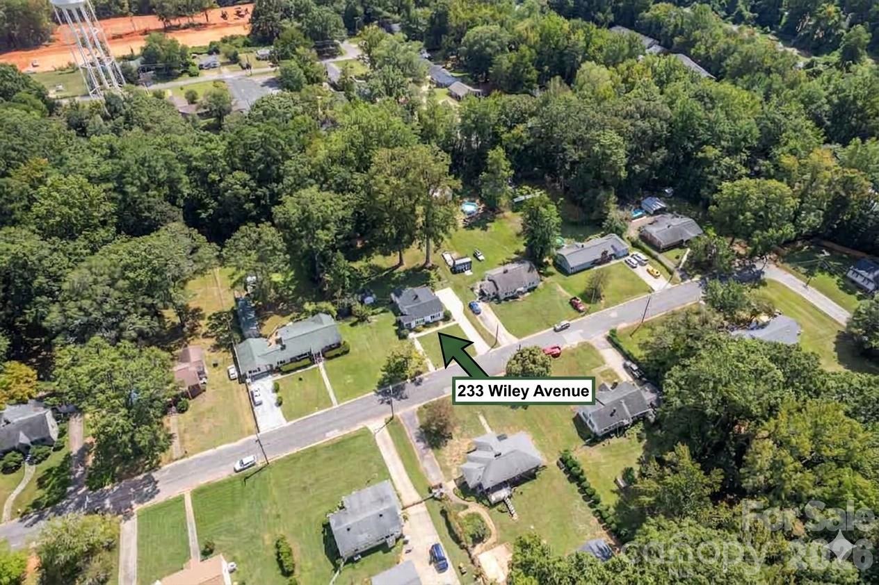 an aerial view of residential house with outdoor space and trees all around