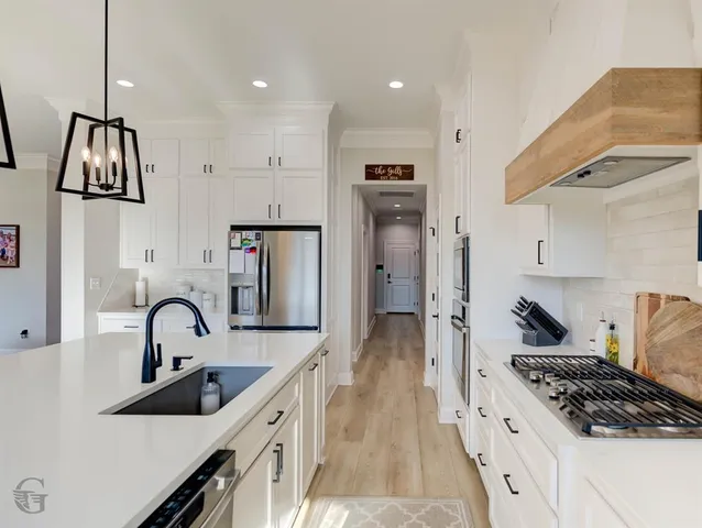 a kitchen with granite countertop a sink stainless steel appliances and cabinets