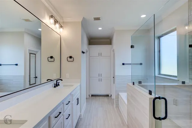 a spacious bathroom with a double vanity sink a mirror and a shower