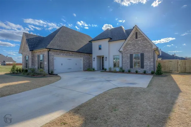 a front view of a house with a yard and a garage