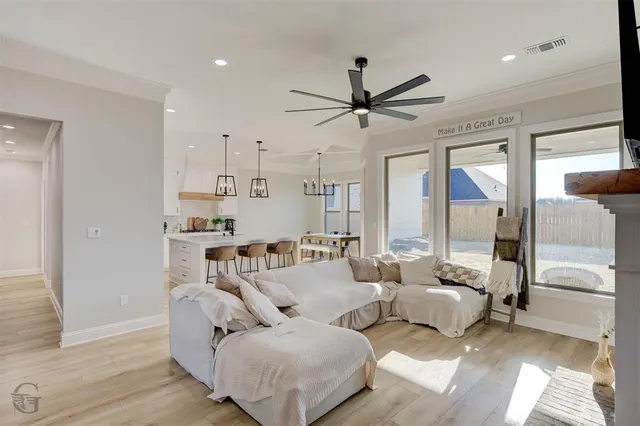 a living room with furniture and a ceiling fan