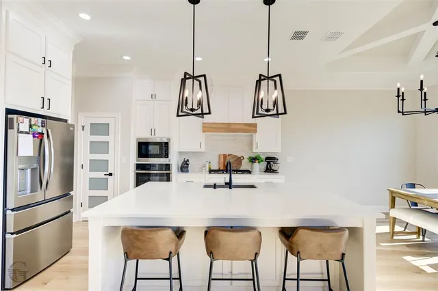 a kitchen with stainless steel appliances kitchen island a refrigerator and a sink