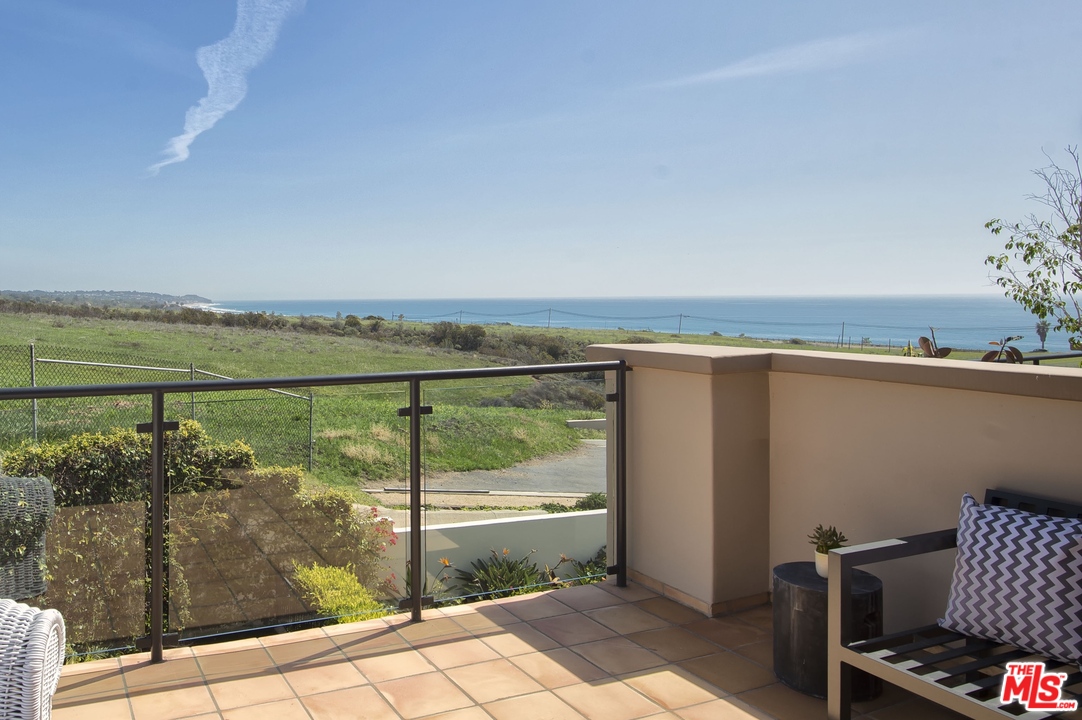 6450 Lunita Road, Unit 122 Malibu, CA 90265 - Photo 1 of 32 a view of a balcony with lake view and a floor to ceiling window