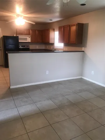 a kitchen with granite countertop a sink a stove and cabinets