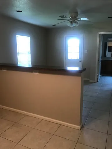 an empty room with windows and fan