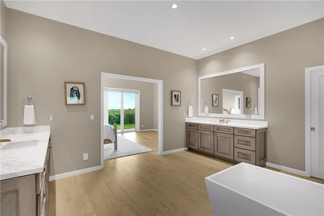a large white kitchen with a granite countertop sink