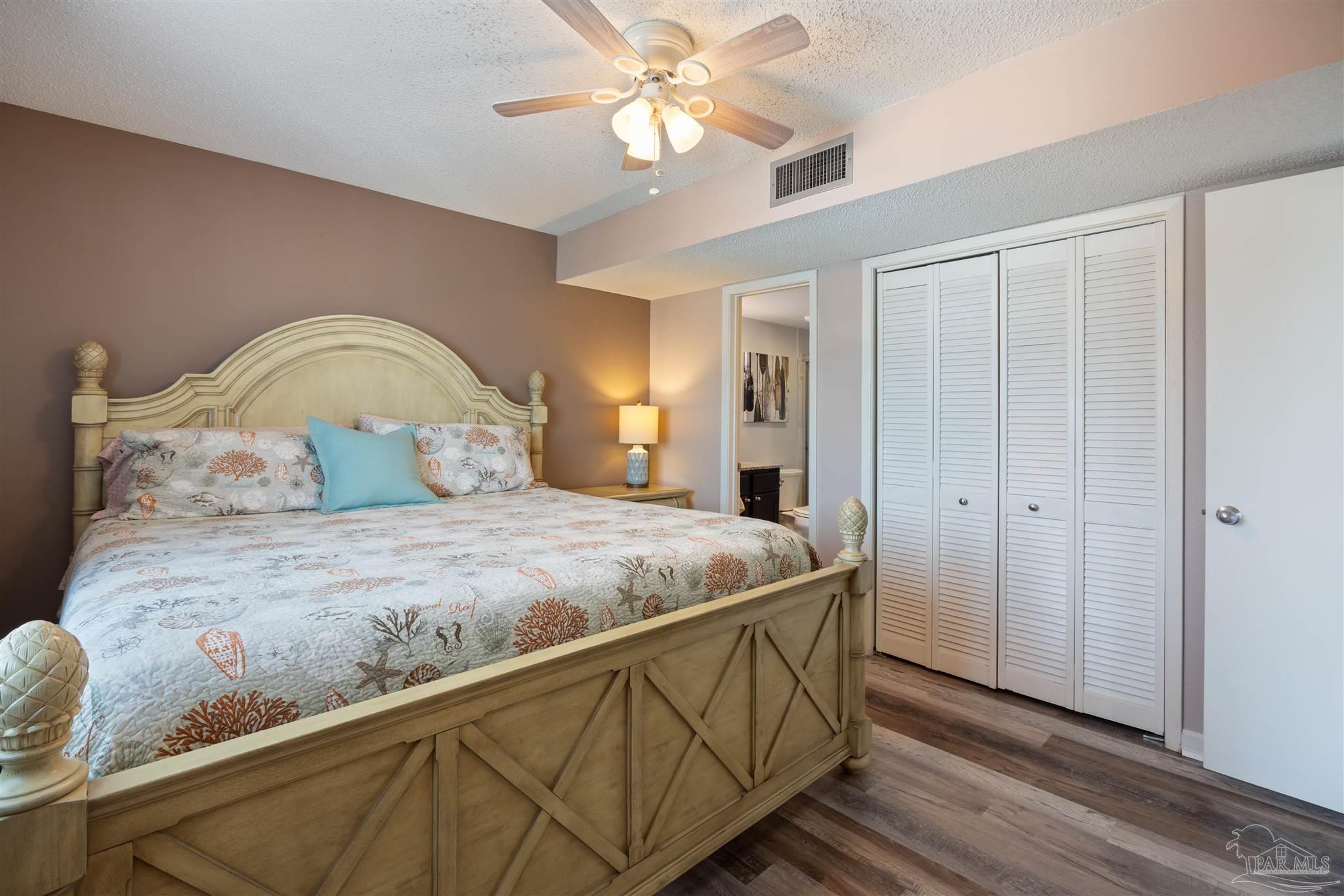 14100 River Road, Unit 228B Pensacola, FL 32507 - Photo 15 of 41 a bedroom with a bed and a chandelier fan
