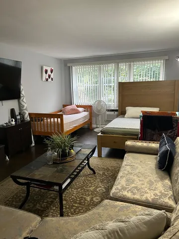 a bedroom with a bed and wooden floor