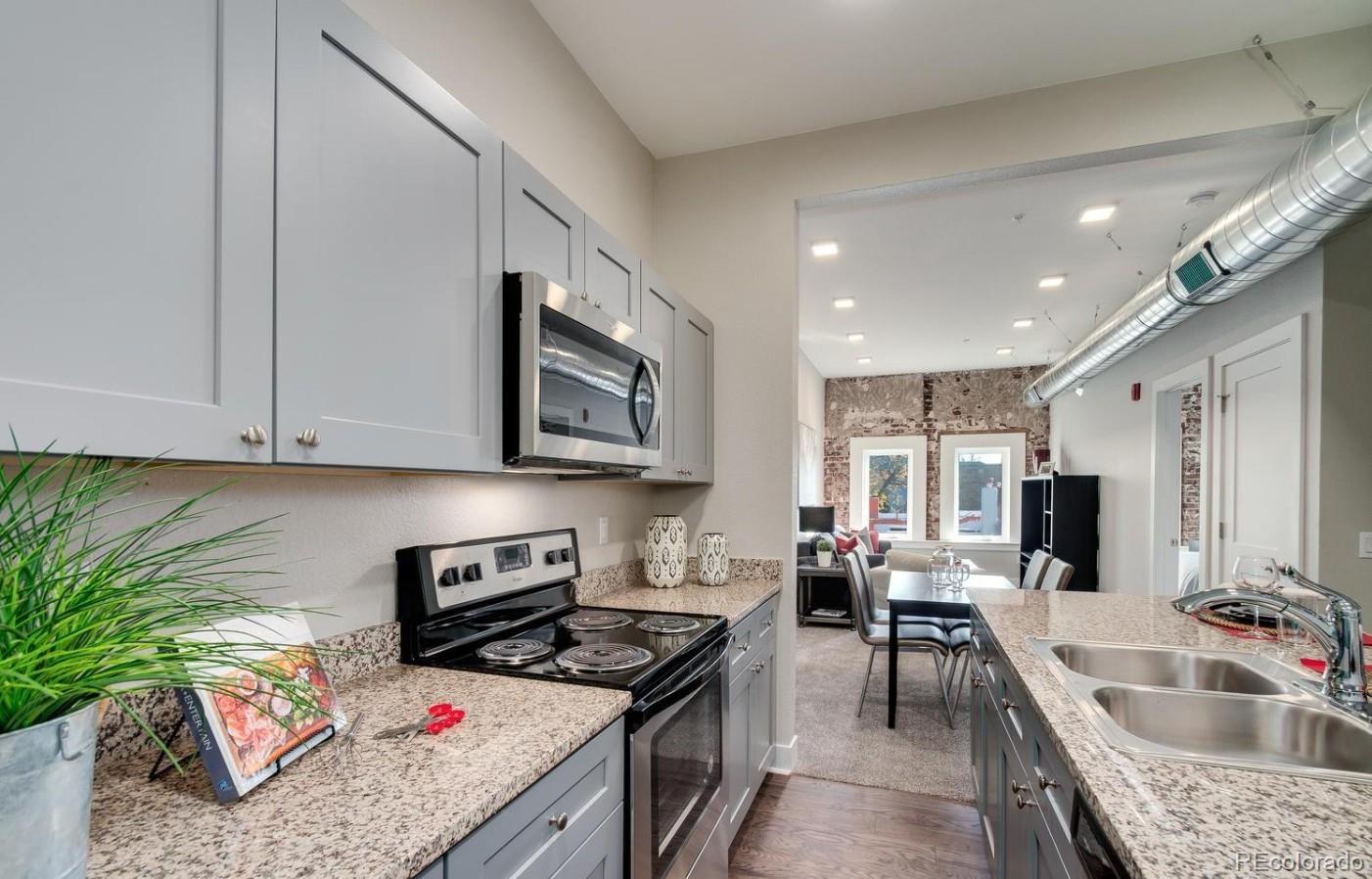 300 South Logan Street, Unit 211 Denver, CO 80209 - Photo 1 of 22 a kitchen with stainless steel appliances granite countertop a sink stove and cabinets
