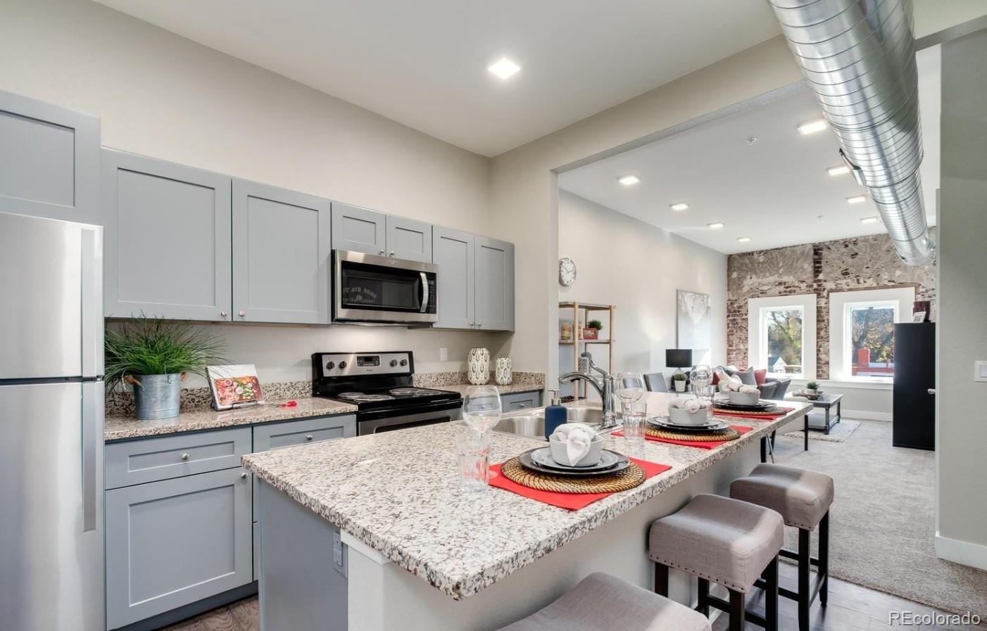 300 South Logan Street, Unit 211 Denver, CO 80209 - Photo 9 of 22 a kitchen with stainless steel appliances kitchen island granite countertop a sink dishwasher a stove a refrigerator a dining table and chairs with wooden floor