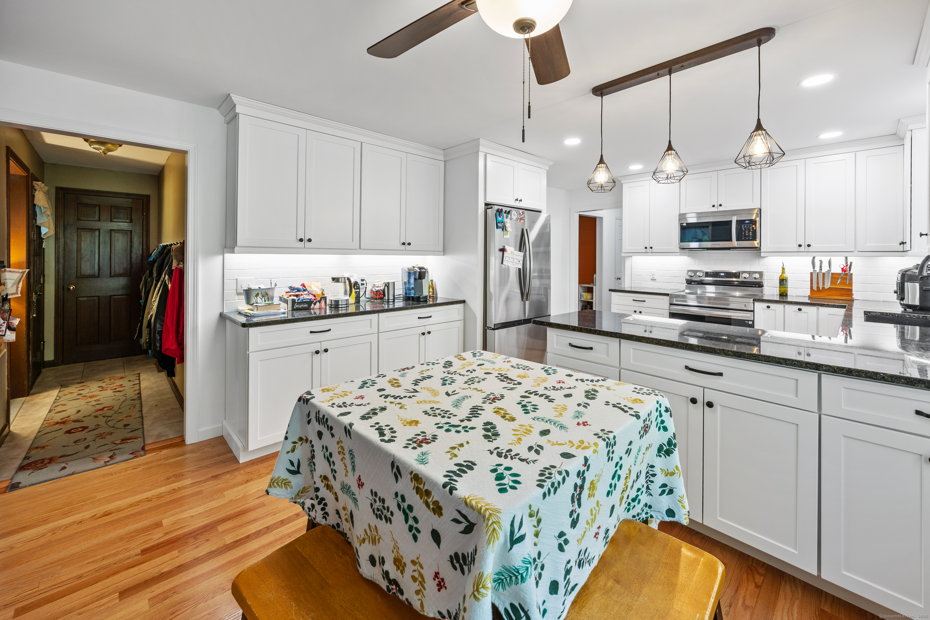 a kitchen with stainless steel appliances kitchen island granite countertop a sink stove and refrigerator