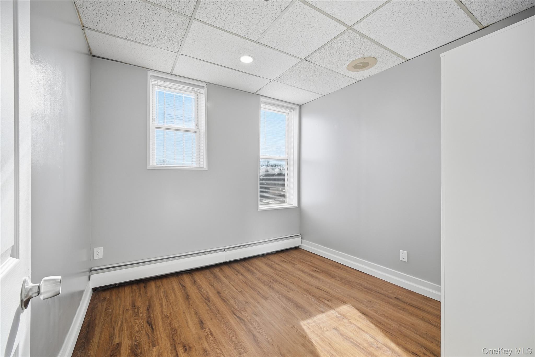 32 B West Main Street, Unit 2 Bay Shore, NY 11706 - Photo 10 of 16 an empty room with wooden floor and windows
