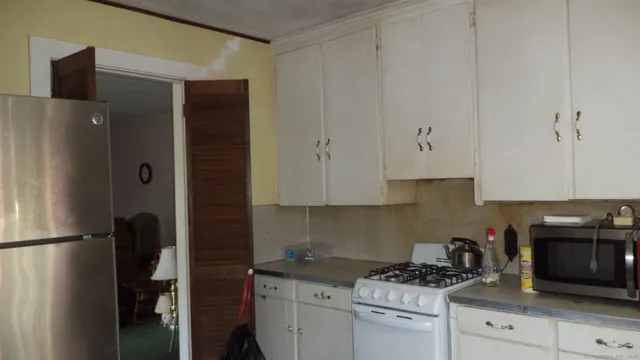 a kitchen with stainless steel appliances white cabinets and a refrigerator