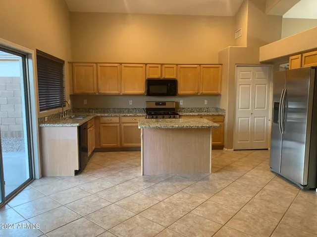 a kitchen with stainless steel appliances granite countertop a stove a sink and a refrigerator