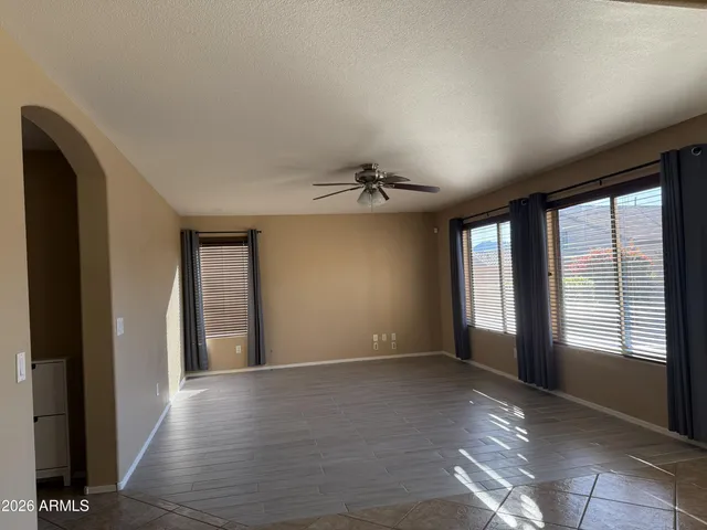 an empty room with windows and chandelier