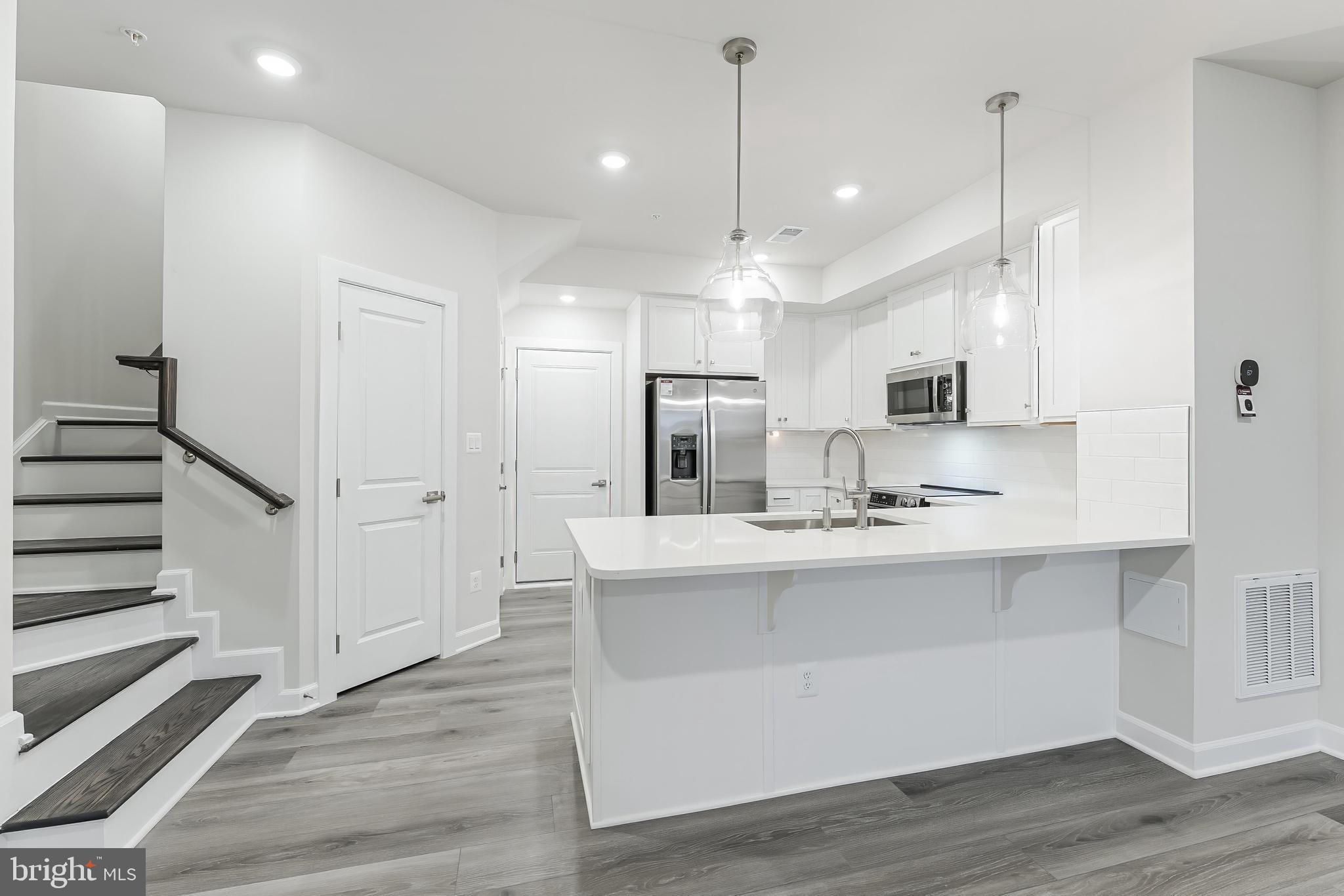 21815 Express Terrace Ashburn, VA 20147 - Photo 2 of 37 a large white kitchen with lots of counter space wooden floor and appliances