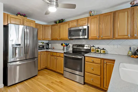 a kitchen with stainless steel appliances granite countertop a refrigerator stove a sink and a microwave