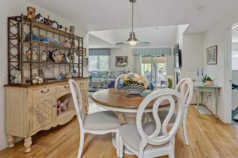 a dining room with furniture a chandelier and wooden floor