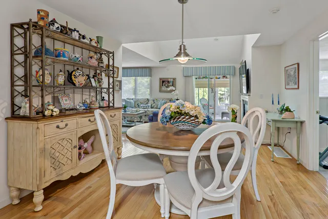 a dining room with furniture a chandelier and wooden floor