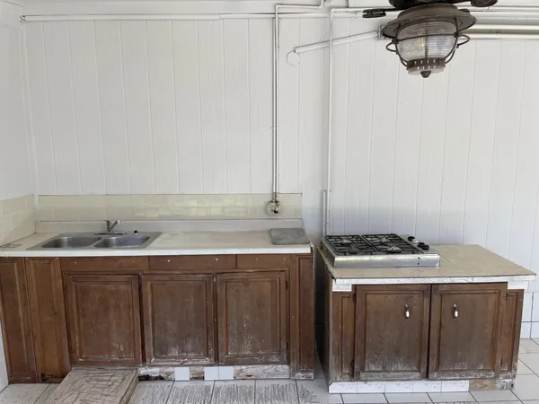 a utility room with stainless steel appliances a stove a sink and a refrigerator