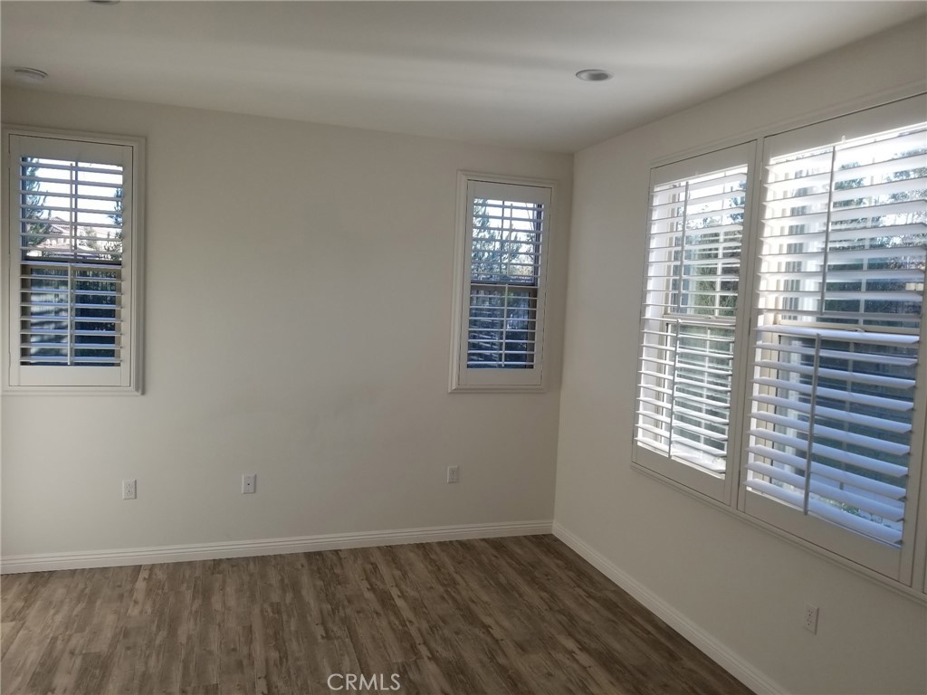 74 Rose Arch Irvine, CA 92620 - Photo 13 of 21 a view of an empty room with wooden floor and a window