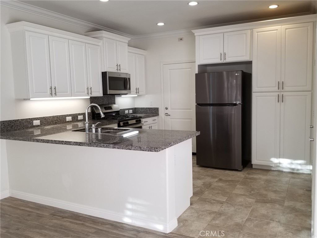 74 Rose Arch Irvine, CA 92620 - Photo 6 of 21 a kitchen with a refrigerator a stove a microwave and cabinets