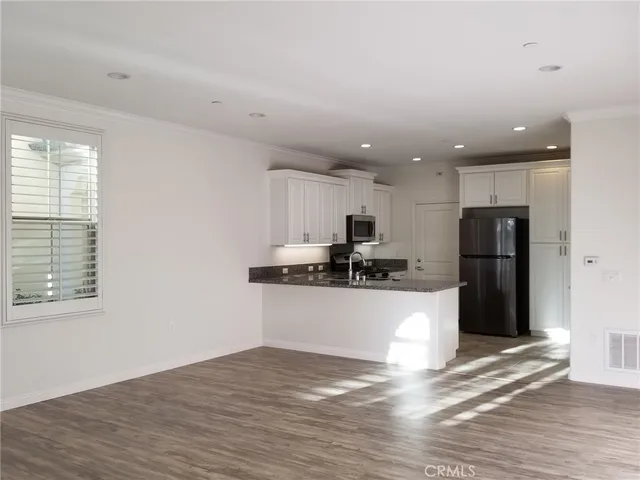 a view of kitchen with refrigerator sink and cabinets