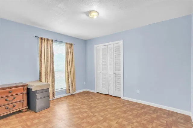 an empty room with windows and closet