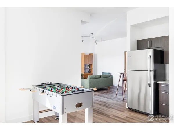 a kitchen with a refrigerator and a wooden floor