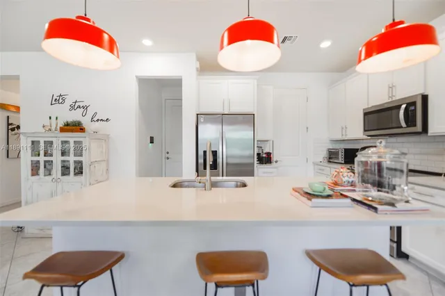a kitchen with a refrigerator and a chair