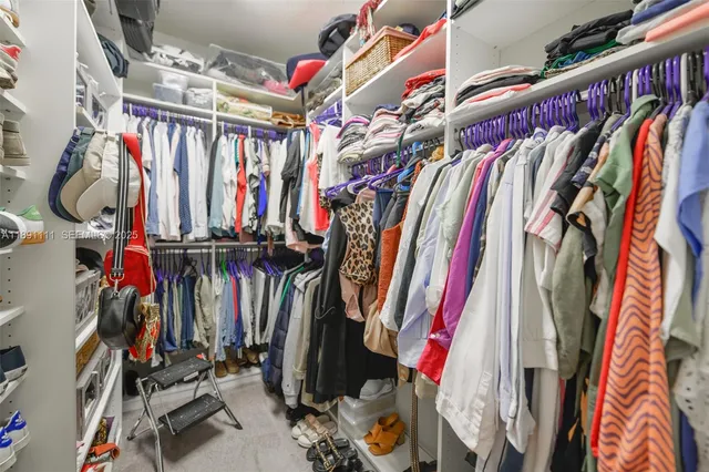 a view of walk in closet with clothes