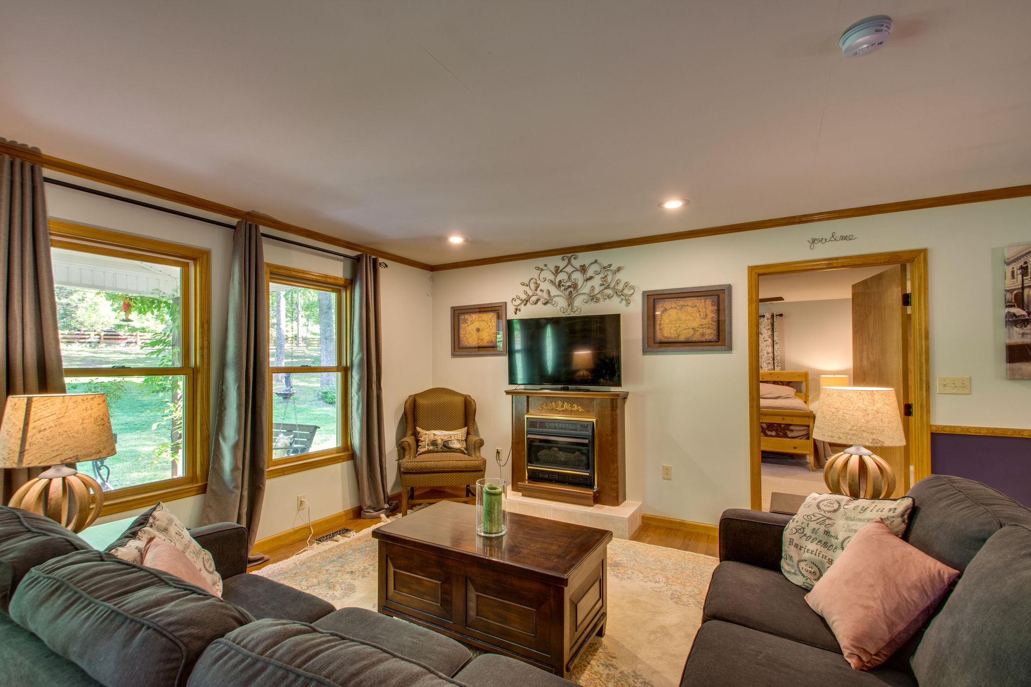 1017 Deer Ridge Road Kingston Springs, TN 37082 - Photo 8 of 29 a living room with furniture a flat screen tv and floor to ceiling window
