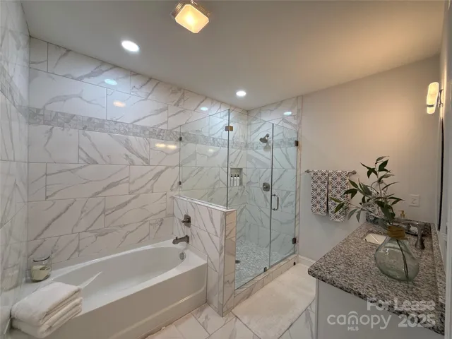 a bathroom with a granite countertop sink a toilet and bathtub