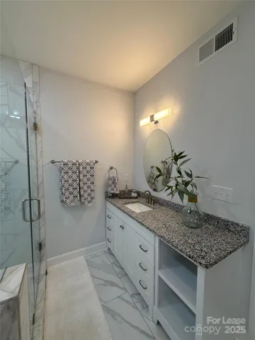 a bathroom with a granite countertop sink and a mirror