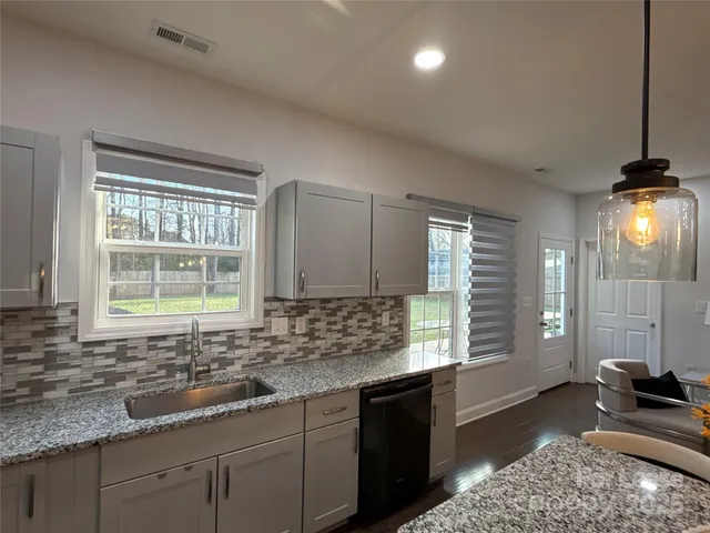 a kitchen with sink a window and cabinets