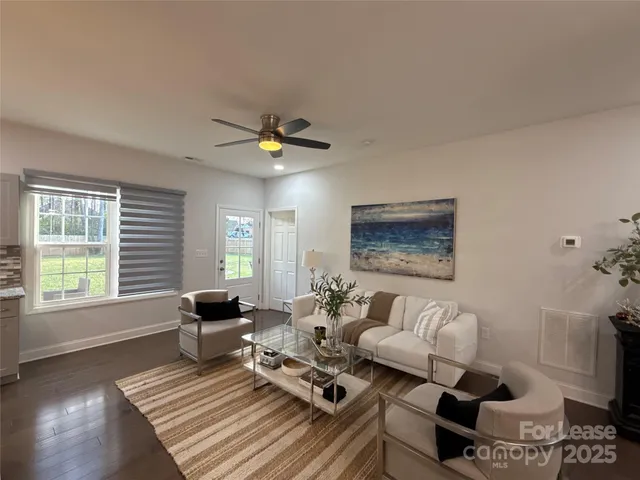 a living room with furniture and wooden floor