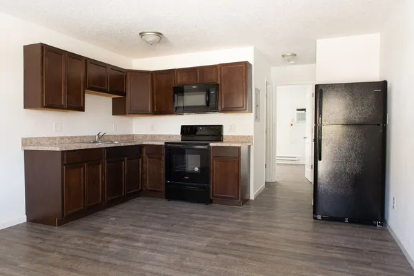 a kitchen with stainless steel appliances granite countertop a refrigerator and a stove top oven