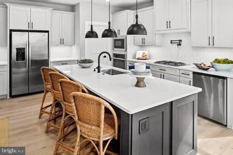 a kitchen with stainless steel appliances a sink a stove a refrigerator and cabinets