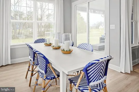 a dining room with furniture a chandelier and wooden floor