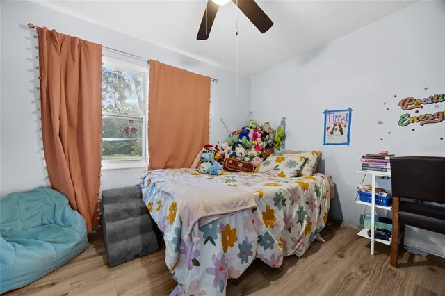 a bedroom with a bed and wooden floor