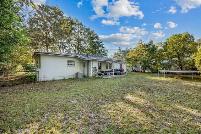 a view of backyard of house with green space