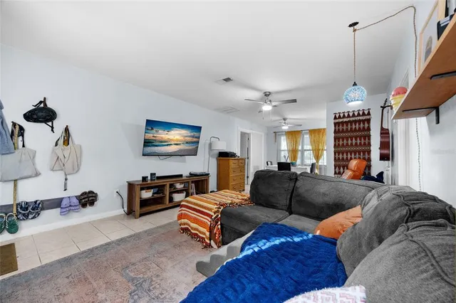 a living room with furniture a ceiling fan and a rug