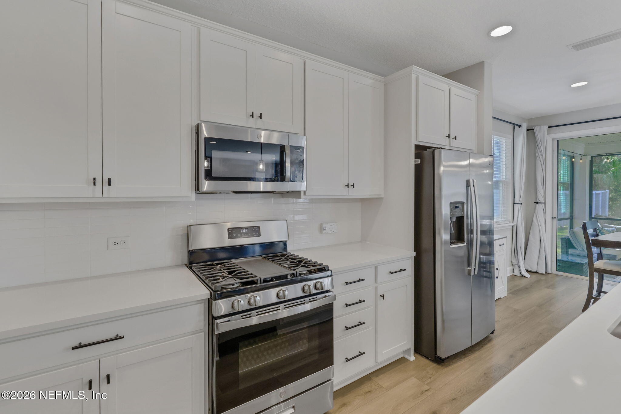 273 Little Bear Run St. Johns, FL 32259 - Photo 9 of 57 a kitchen with stainless steel appliances white cabinets and a stove a refrigerator with wooden floor